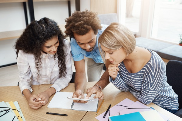 três pessoas estuando e criando uma estratégia para a preparação para o ENEM